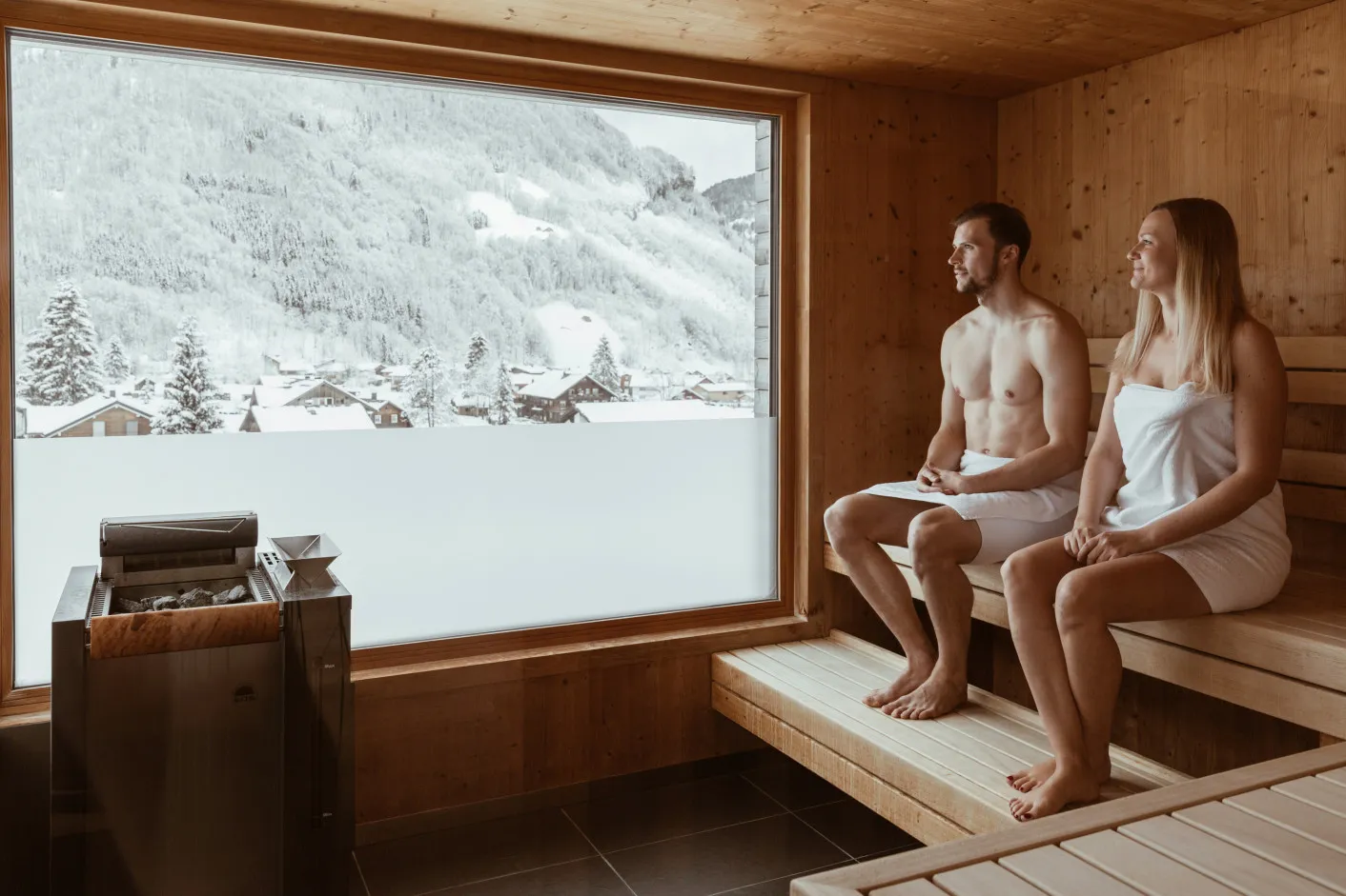Aparthotel Hubertus Mellau – Sauna mit Panoramablick auf die verschneiten Berge des Bregenzerwald für einen erholsamen Urlaub in Vorarlberg.